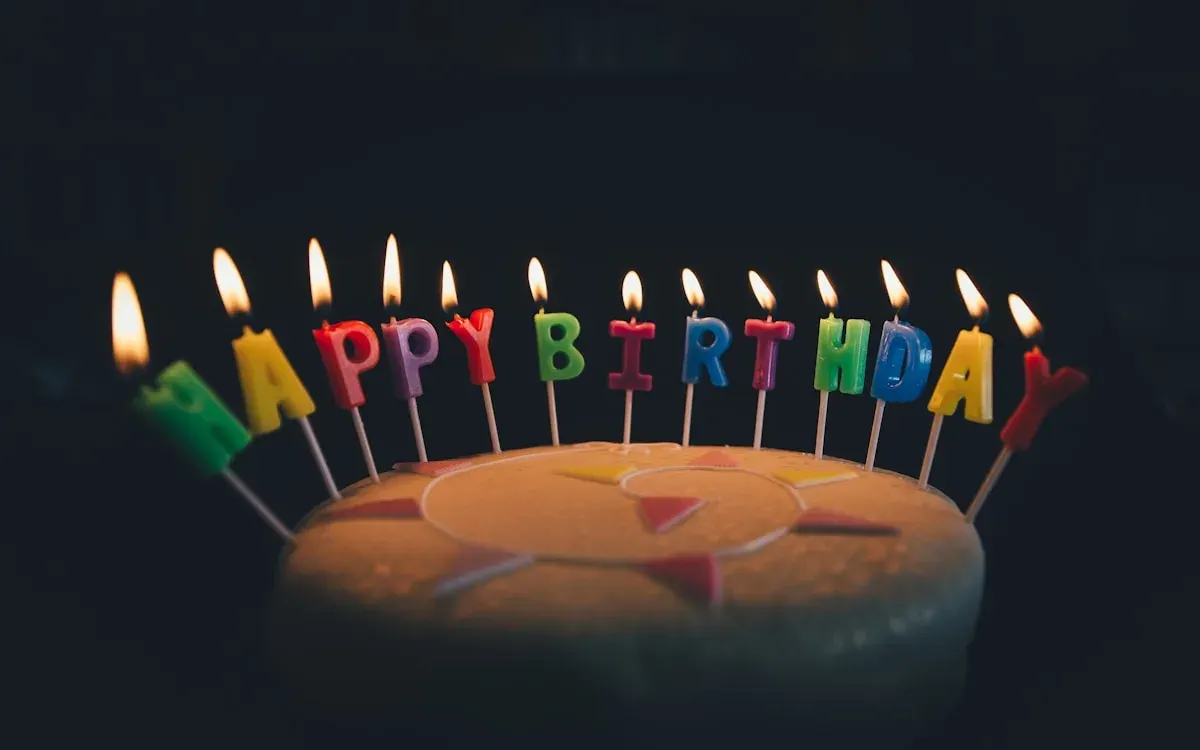蛋糕上点燃的 HAPPY BIRTHDAY 字母蜡烛